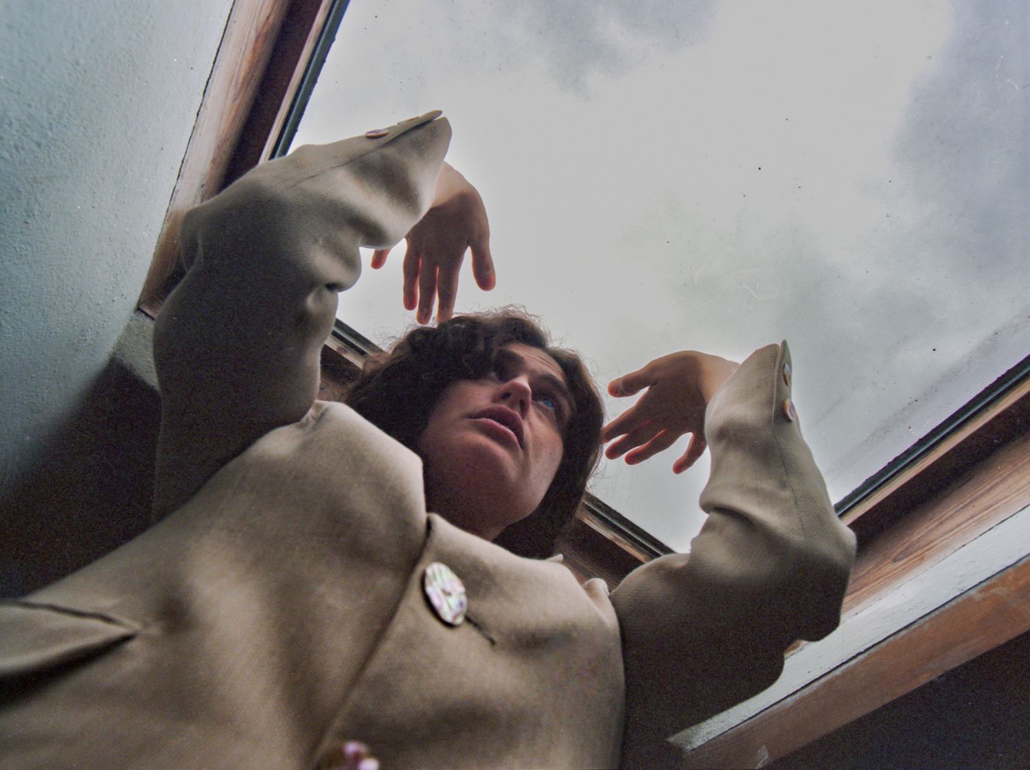 A person reaching up near a window